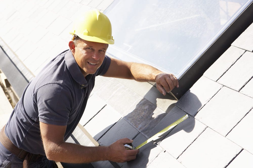 A roofer installing shingles.